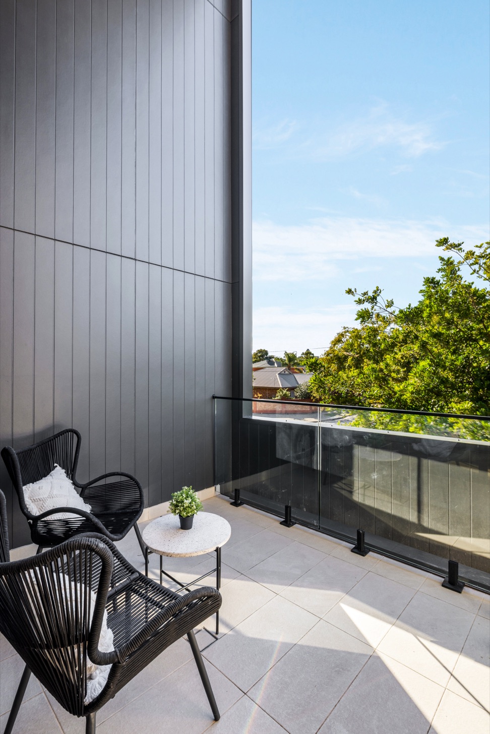 Private balcony with outdoor seating and a glass balustrade.