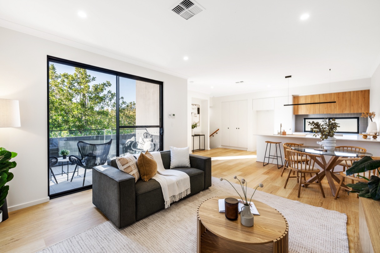 Open-plan living, dining and kitchen area opening onto the balcony.