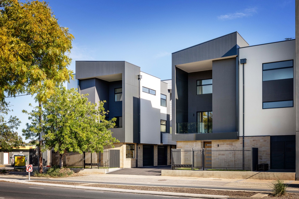 Street view of the Ninety Eight Churchill townhouses beneath established street trees.