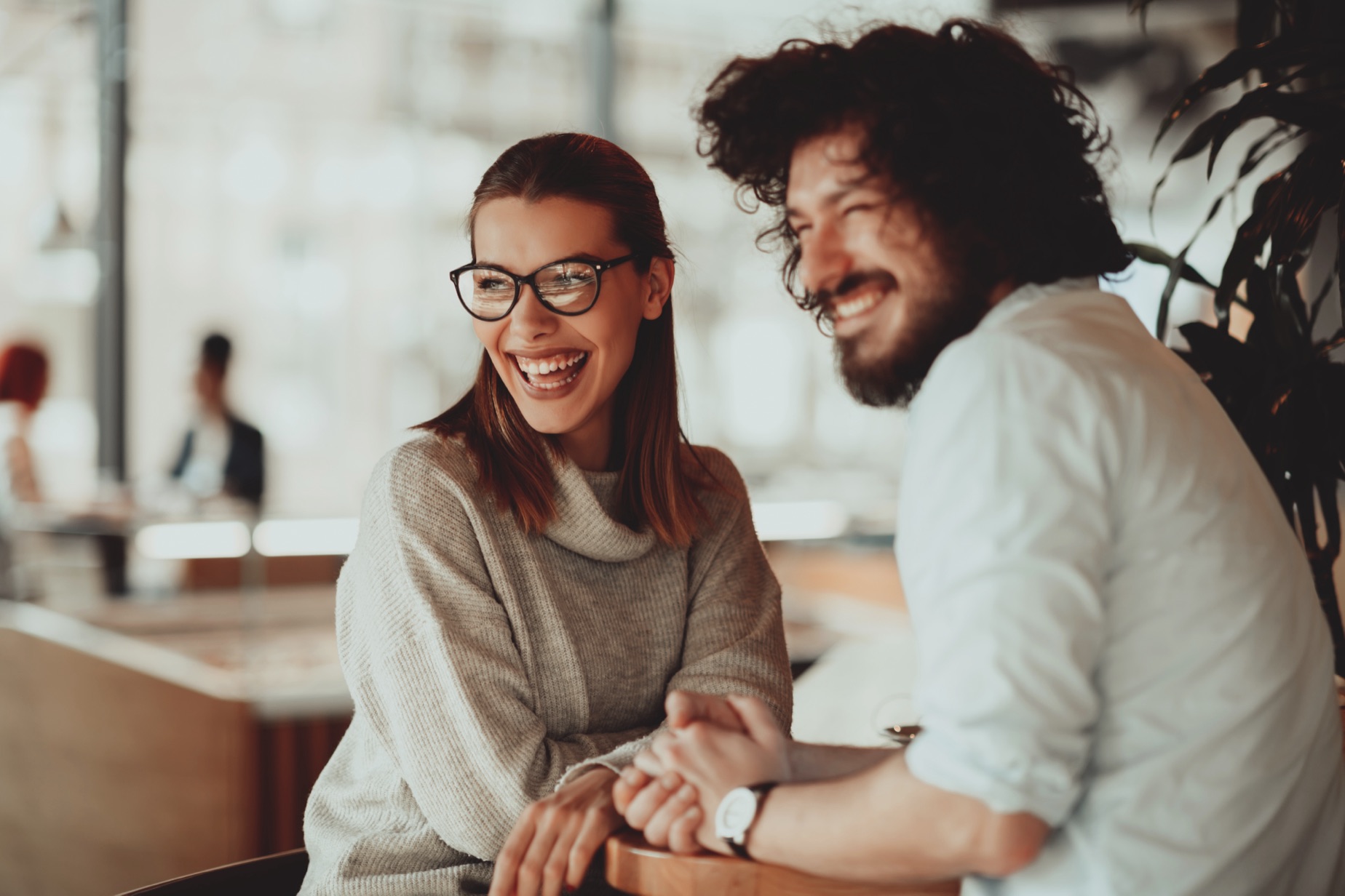 A couple laughing together at a cafe counter